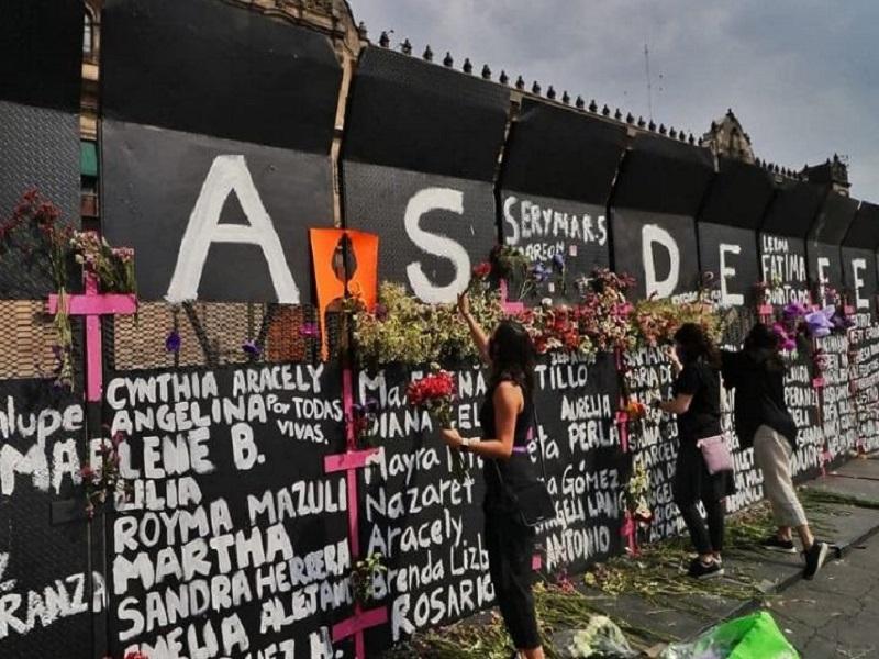 Mujeres colocan flores en las vallas de Palacio Nacional