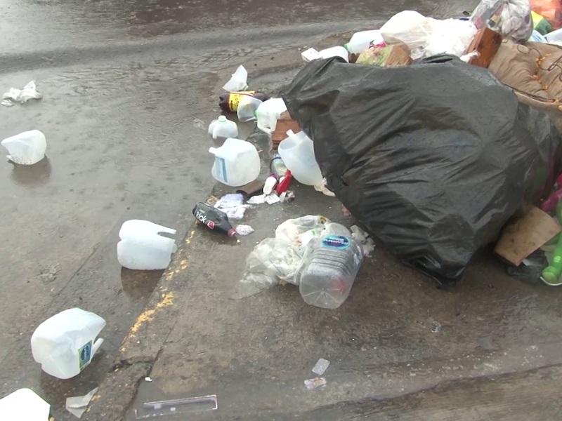 Migrantes rompen bolsas de basura para buscar productos reciclables