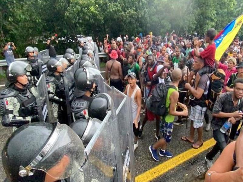 A golpes y empujones migrantes rompen cerco de la GN en Chiapas, avanzan hacia la capital para protestar por lento proceso de asilo
